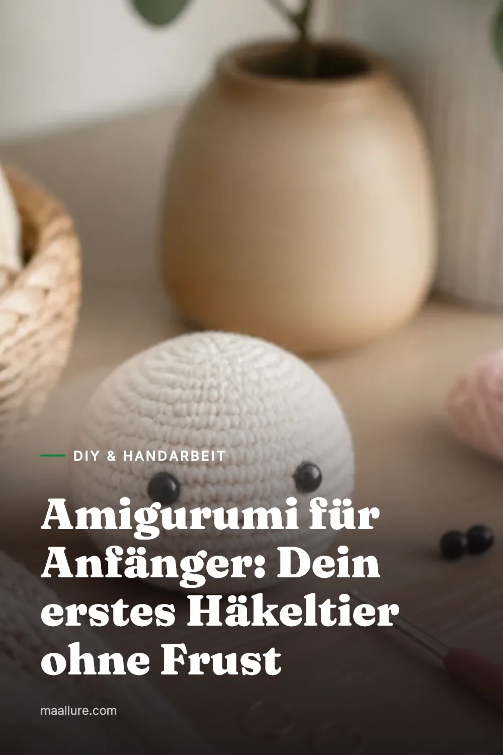 Kleines gehäkeltes Amigurumi-Tier auf einem Tisch mit Garnknäuel, Häkelnadel und Maschenmarkierer