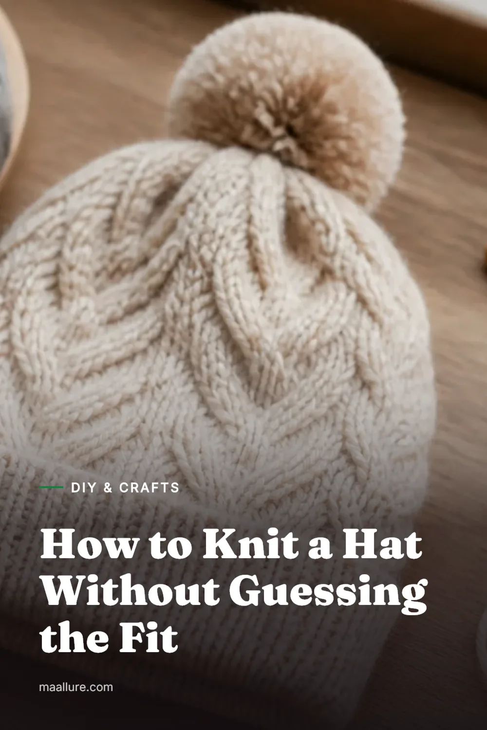 A handmade knitted beanie with yarn, needles, and a tape measure on a wooden table in soft light.