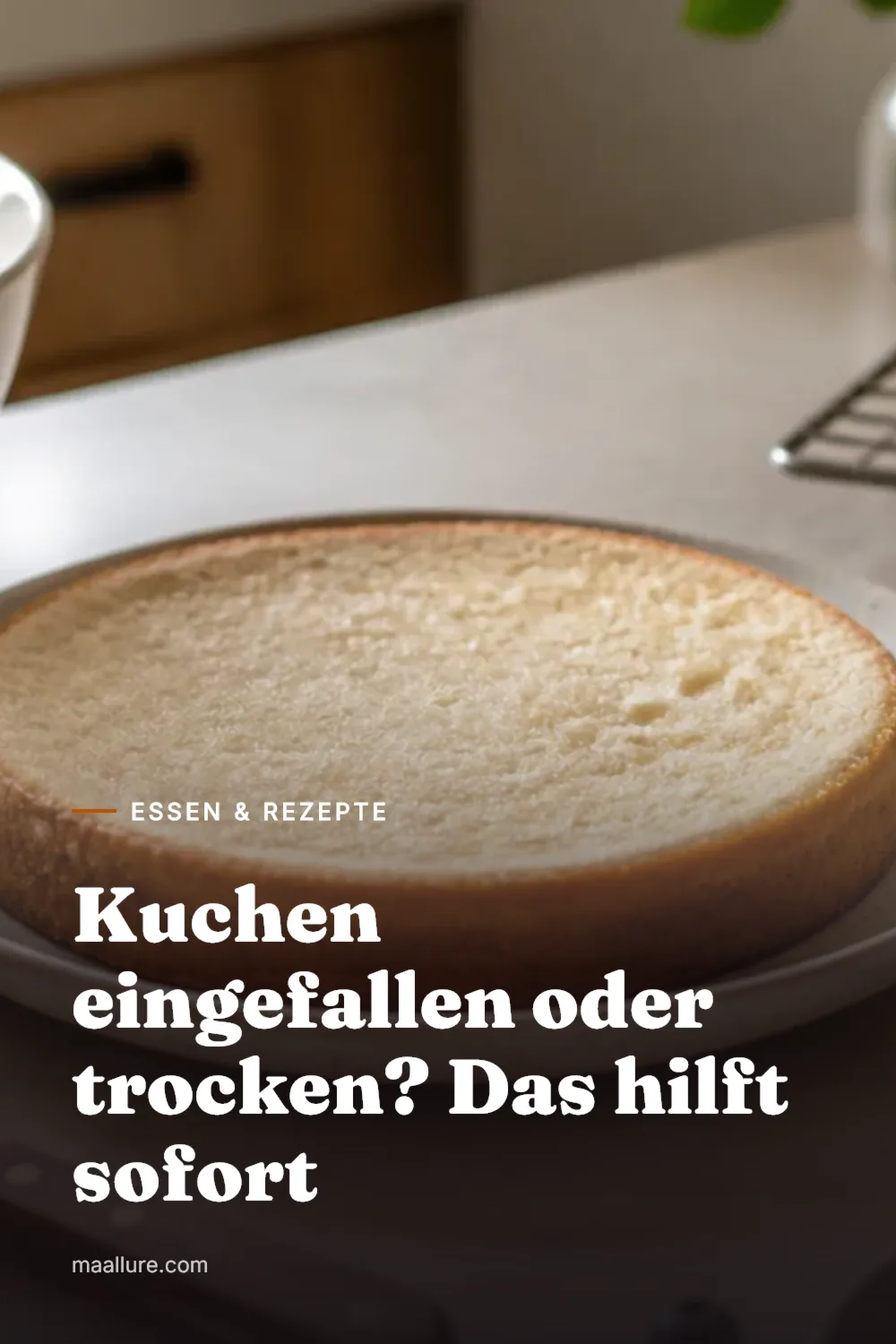 Ein leicht in der Mitte eingesunkener Biskuitkuchen auf einem Kuchengitter in einer hellen Küche