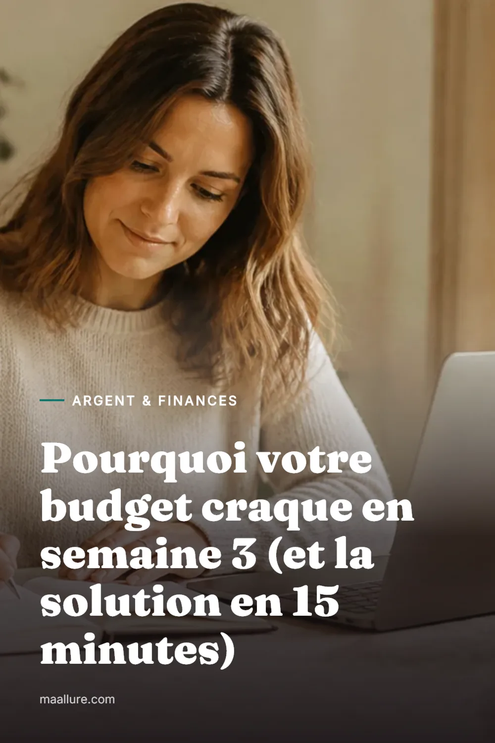Femme qui fait sereinement le point sur son budget mensuel dans un carnet, à côté d'un ordinateur portable et d'une tasse de thé, sur une table de cuisine baignée de soleil
