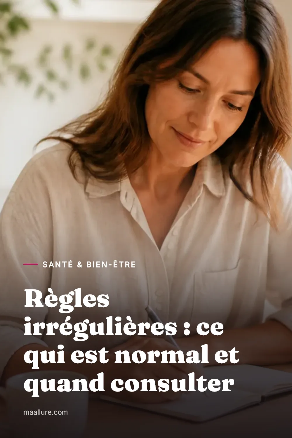Femme notant sereinement des informations dans un petit carnet de cycle à une table de cuisine ensoleillée, une tasse de thé à côté