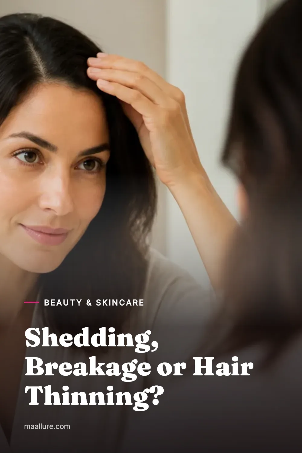 Woman gently checking her hair part in a softly lit bathroom mirror