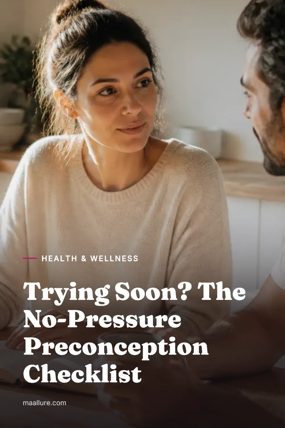 A couple sitting at a sunlit kitchen table with a notebook and tea, calmly planning together before trying for a baby